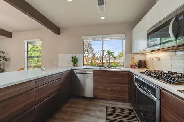 a kitchen with stainless steel appliances granite countertop a refrigerator sink and stove
