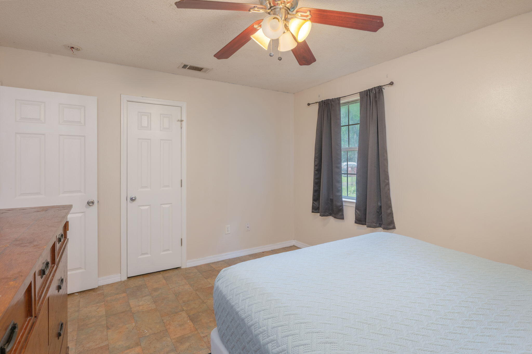 834 McDonald Street Crestview, FL 32536 - Photo 13 of 35 a bedroom with a bed and a chandelier