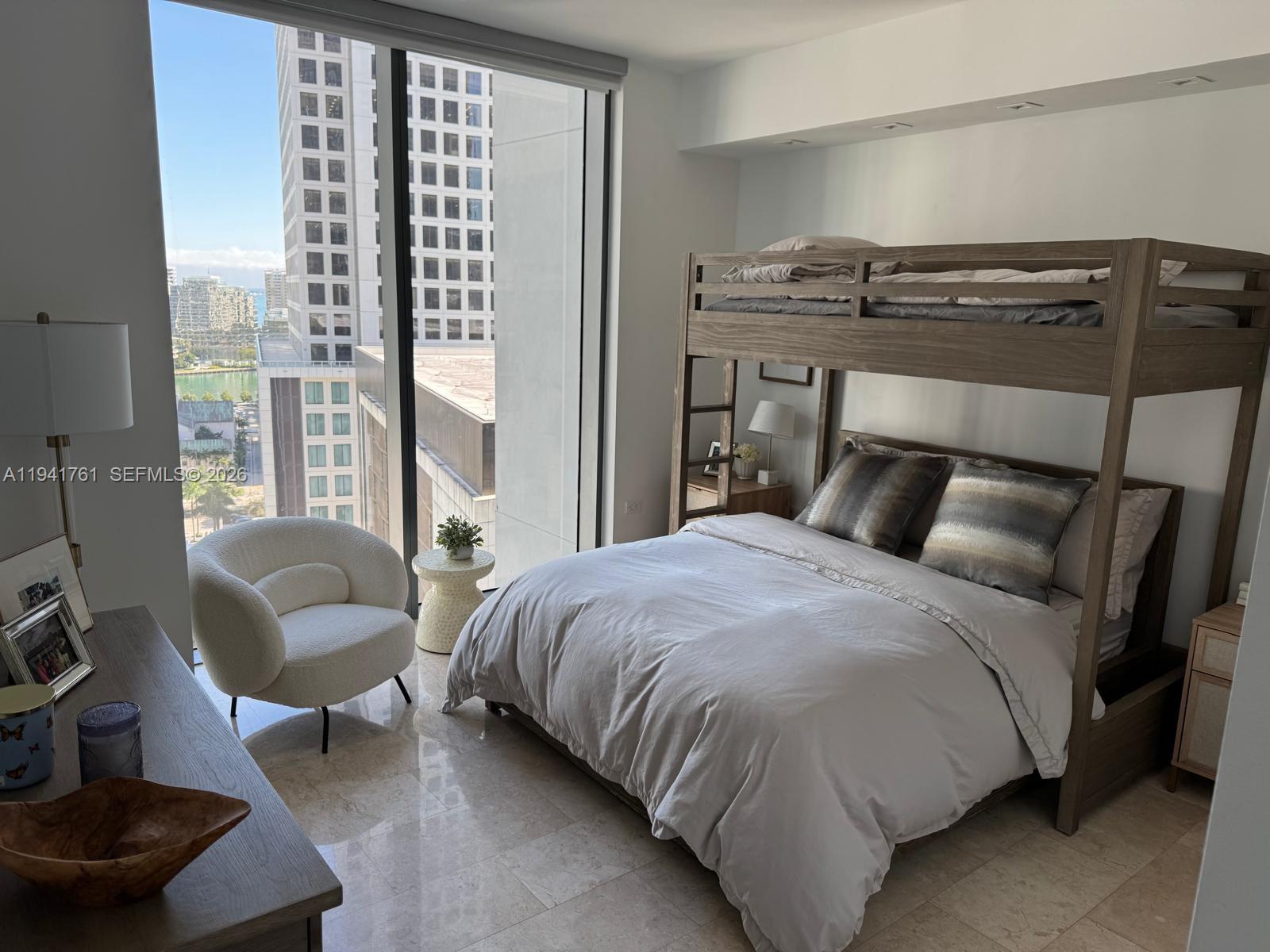 68 Southeast 6th Street, Unit 1109 Miami, FL 33131 - Photo 13 of 23 a bedroom with a bed and a couch next to a window