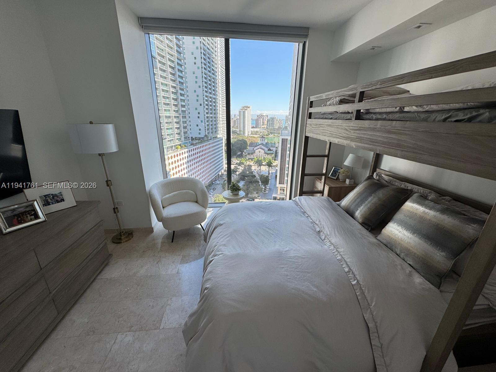 68 Southeast 6th Street, Unit 1109 Miami, FL 33131 - Photo 14 of 23 a bedroom with a bed and large windows