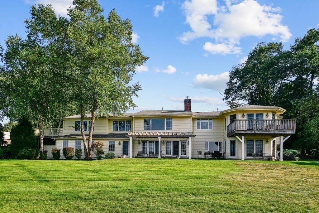 106 Forbes Road Milton, MA 02186 - Photo 7 of 27 a view of a big house with a big yard and large trees