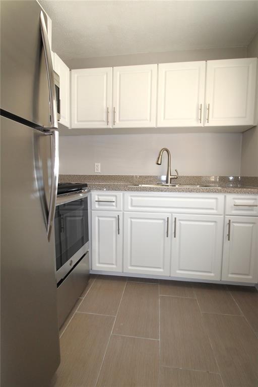 3001 Bee Ridge Road, Unit 121 Sarasota, FL 34239 - Photo 3 of 19 a kitchen with white cabinets stainless steel appliances and a window
