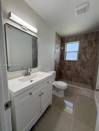 a bathroom with a toilet a sink a mirror and a bathtub
