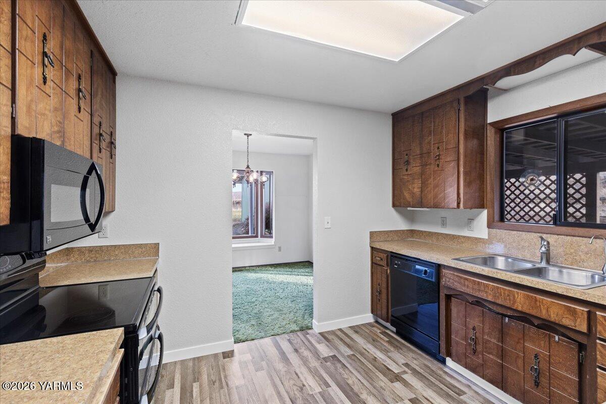10802 Zier Road Yakima, WA 98908 - Photo 21 of 46 a kitchen with granite countertop a sink a stove and cabinets
