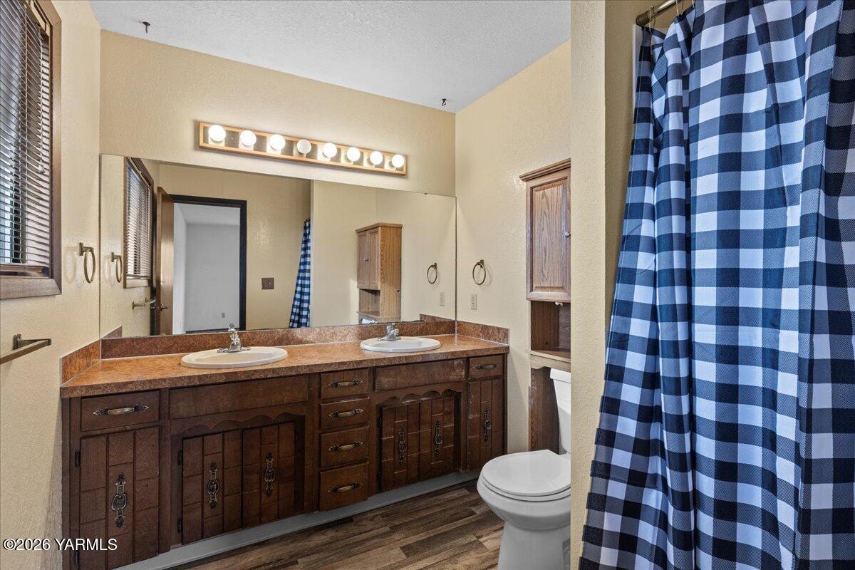 10802 Zier Road Yakima, WA 98908 - Photo 40 of 46 a spacious bathroom with a granite countertop toilet a sink a mirror and a shower