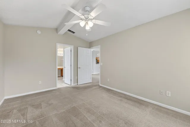 an empty room with a ceiling fan and window