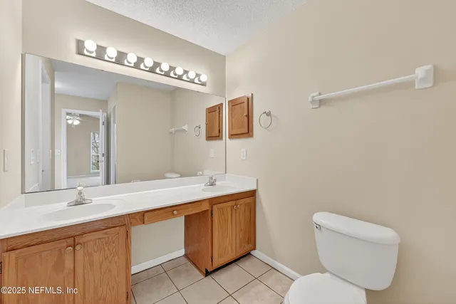 a bathroom with a toilet a sink and mirror