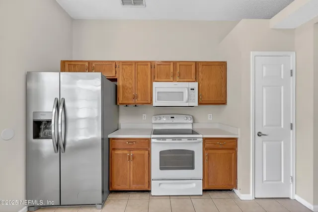 a kitchen with a stove top oven and refrigerator