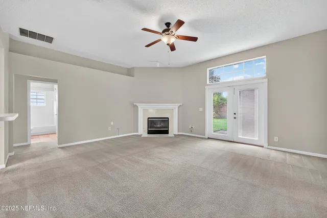 an empty room with fan and windows