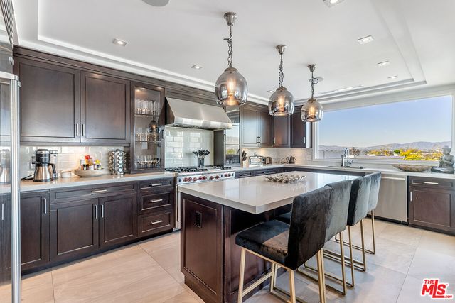 a kitchen with a chandelier a sink and cabinets