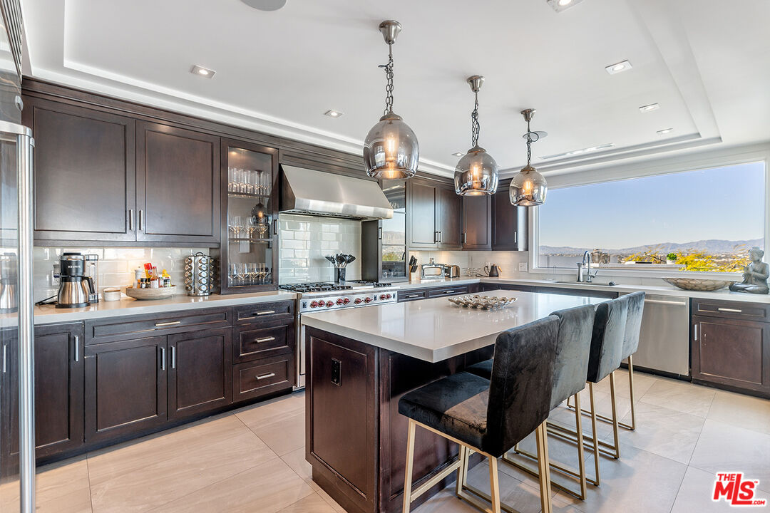 10901 Terryview Drive Studio City, CA 91604 - Photo 14 of 50 a kitchen with a chandelier a sink and cabinets