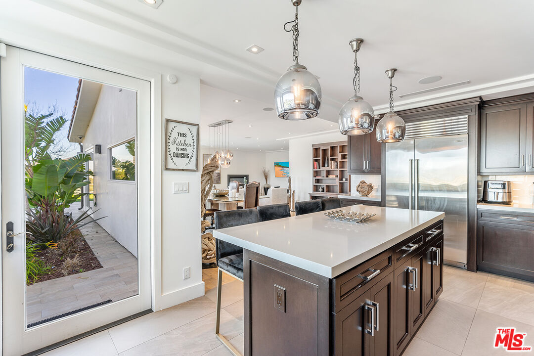 10901 Terryview Drive Studio City, CA 91604 - Photo 16 of 50 a kitchen that has a kitchen center island and a table in it