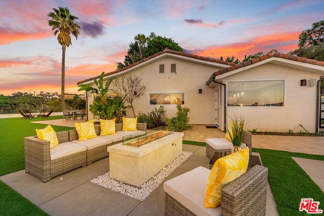 a front view of a house with swimming pool and dining table