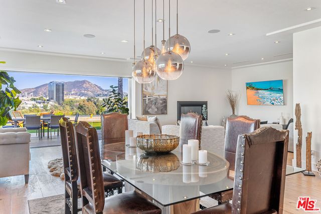 a view of a dining room with furniture a chandelier and wooden floor