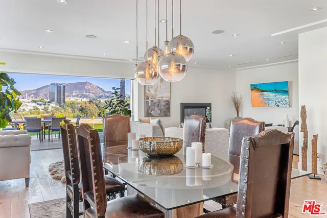 a view of a dining room with furniture a chandelier and wooden floor