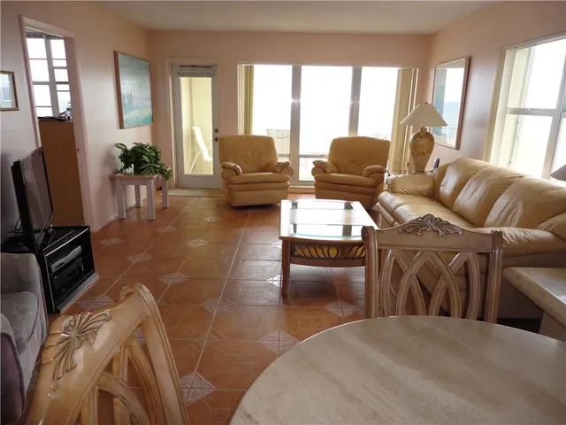 a living room with furniture fireplace and large windows