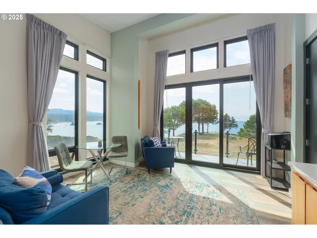 a living room with furniture and floor to ceiling windows