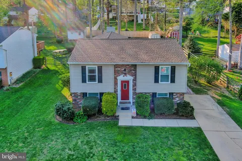 a front view of a house with a yard and potted plants