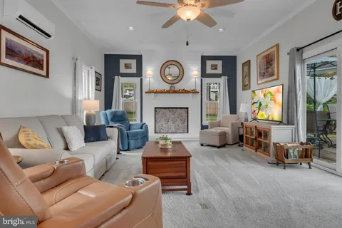 a living room with furniture a fireplace and a large window