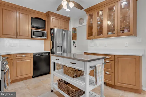 a kitchen with stainless steel appliances granite countertop a refrigerator a stove and a sink with wooden cabinets