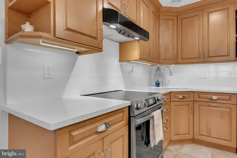 a kitchen with stainless steel appliances granite countertop a stove and cabinets