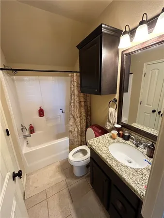 a bathroom with a granite countertop sink a mirror and a toilet