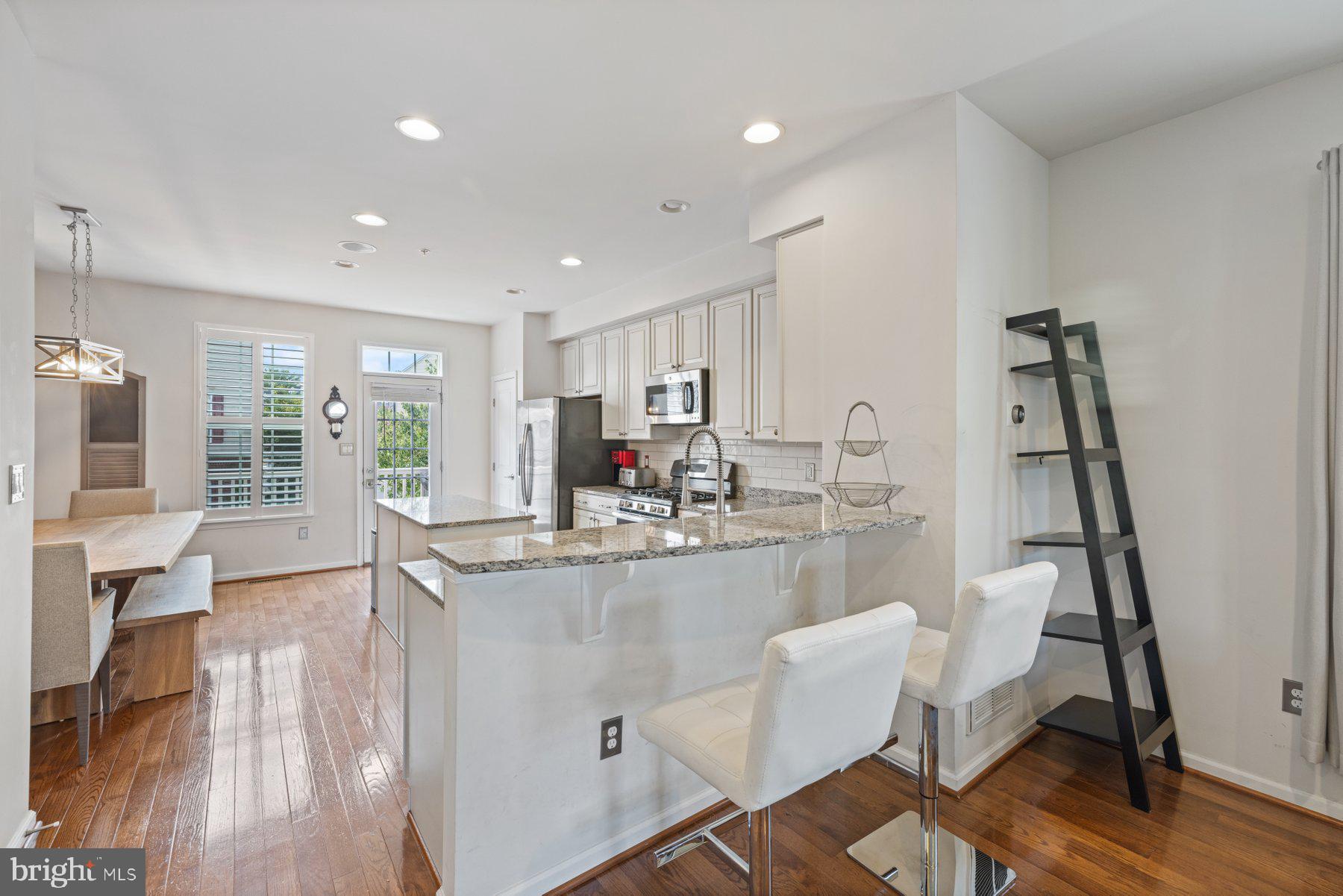 2514 Ralph Ellison Way Northeast Washington, DC 20018 - Photo 11 of 31 a kitchen with kitchen island stainless steel appliances sink dining table and chairs