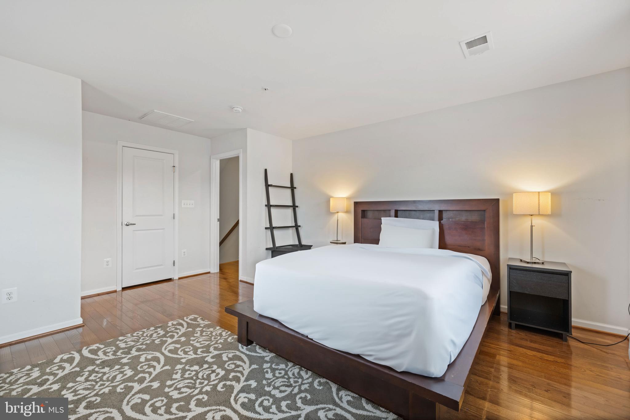 2514 Ralph Ellison Way Northeast Washington, DC 20018 - Photo 25 of 31 a bedroom with a bed and a lamp with wooden floor