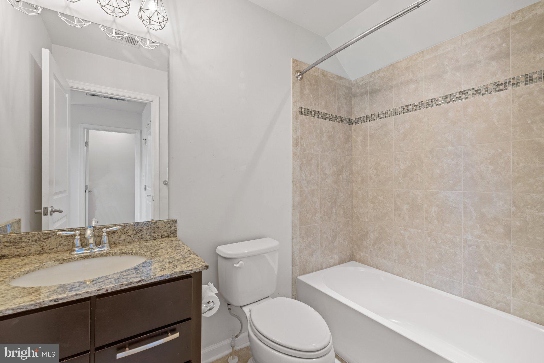 2514 Ralph Ellison Way Northeast Washington, DC 20018 - Photo 31 of 31 a bathroom with a granite countertop sink toilet and shower