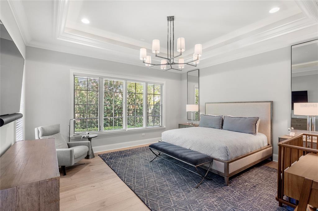 10224 Mattraw Place Orlando, FL 32836 - Photo 15 of 43 a spacious bedroom with a bed a couch and a chandelier