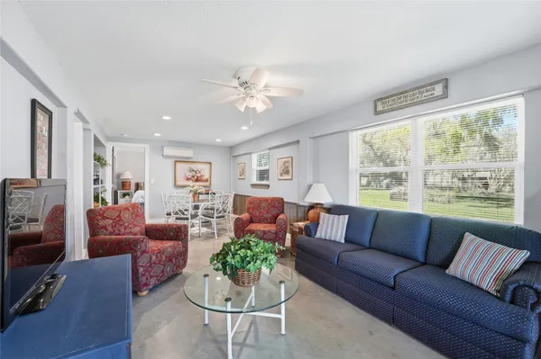 a living room with furniture fireplace and a large window