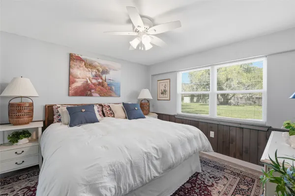 a bedroom with a bed and a large window