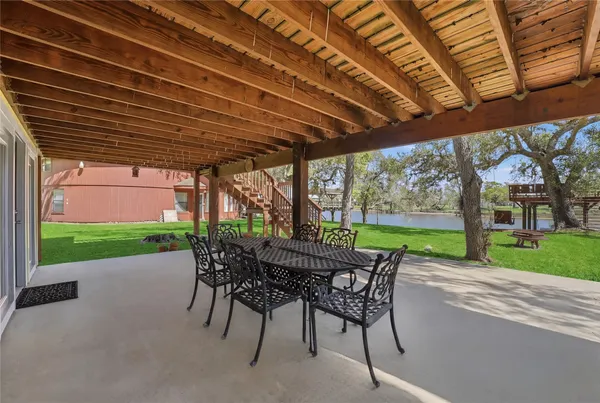 a view of a patio with a table chairs and a backyard