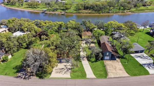 an aerial view of a house with a yard and lake view