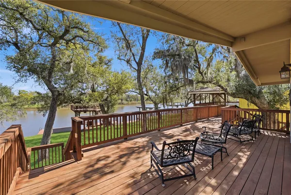 a balcony with wooden floor table and chairs