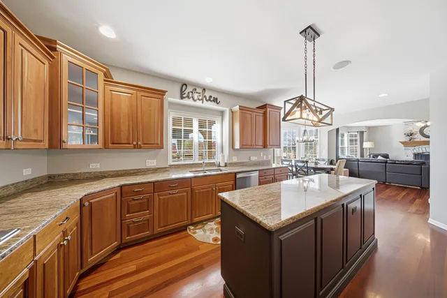 a kitchen with stainless steel appliances granite countertop a refrigerator a stove and a wooden floors