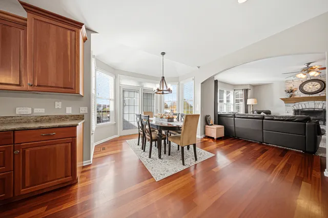 a kitchen with stainless steel appliances granite countertop a stove a sink dishwasher and wooden cabinets with wooden floor