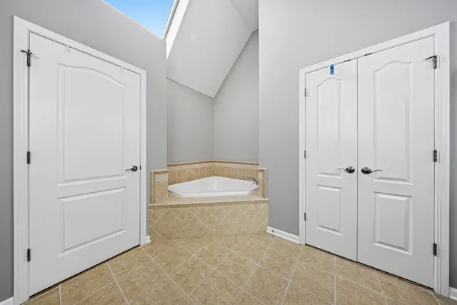 a spacious bathroom with a double vanity sink mirror and bathtub