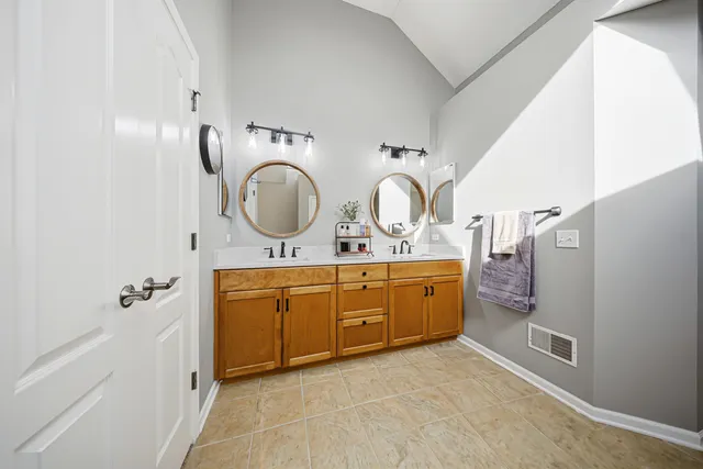 a bathroom with a double vanity sink mirror and toilet