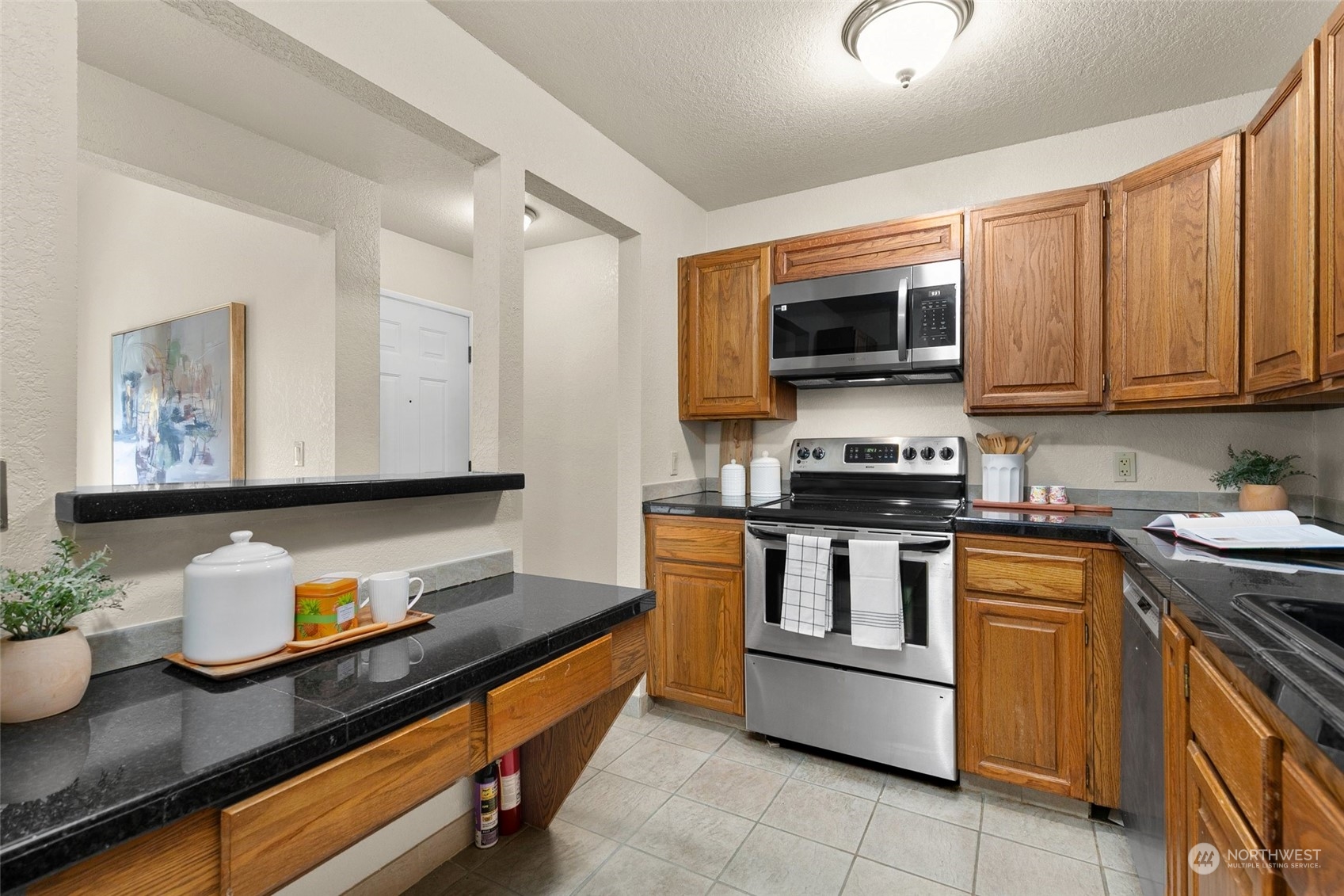 13626 Northeast 7th Street, Unit F16 Bellevue, WA 98005 - Photo 8 of 22 a kitchen with stainless steel appliances granite countertop a stove a sink and a microwave
