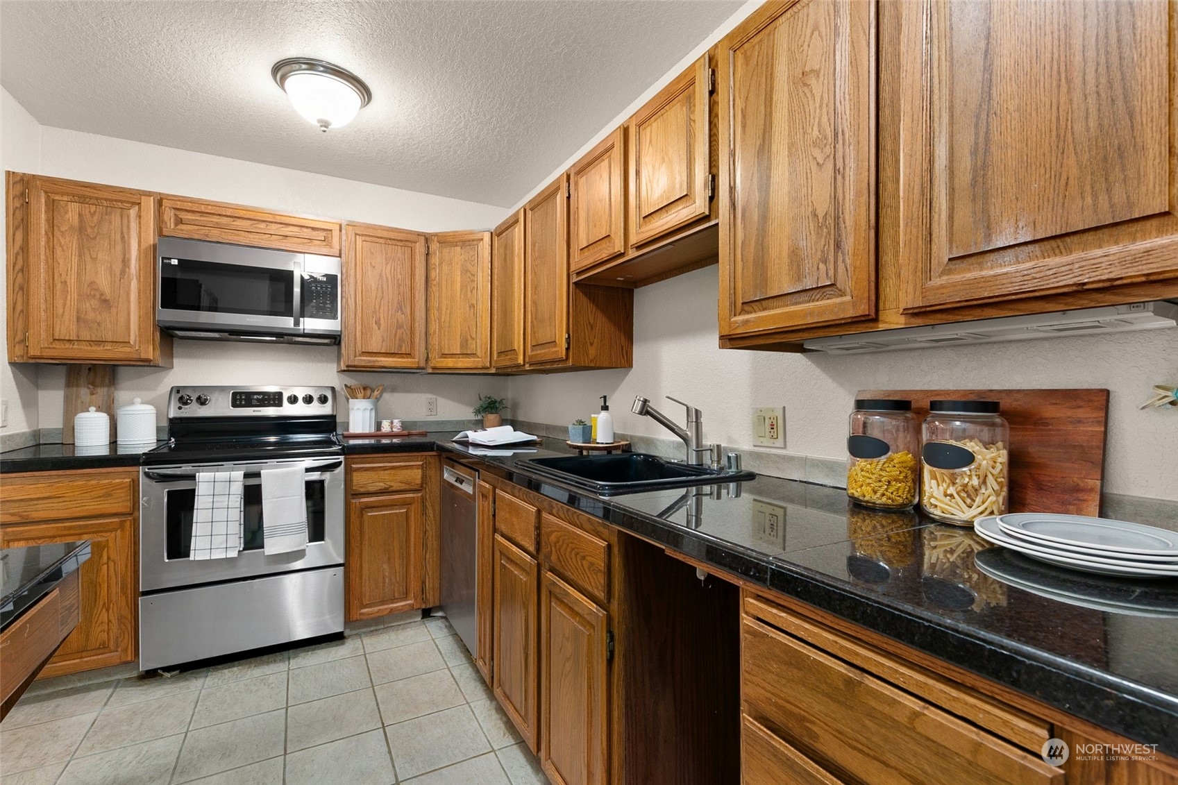 13626 Northeast 7th Street, Unit F16 Bellevue, WA 98005 - Photo 9 of 22 a kitchen with stainless steel appliances granite countertop a stove a sink and a microwave