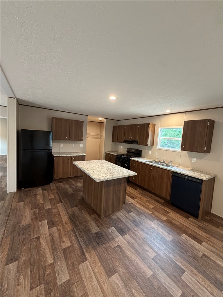 1411 Slaton Road Townville, SC 29689 - Photo 8 of 17 Rich wood-look flooring complements the warm cabinetry and central island of this functional kitchen.