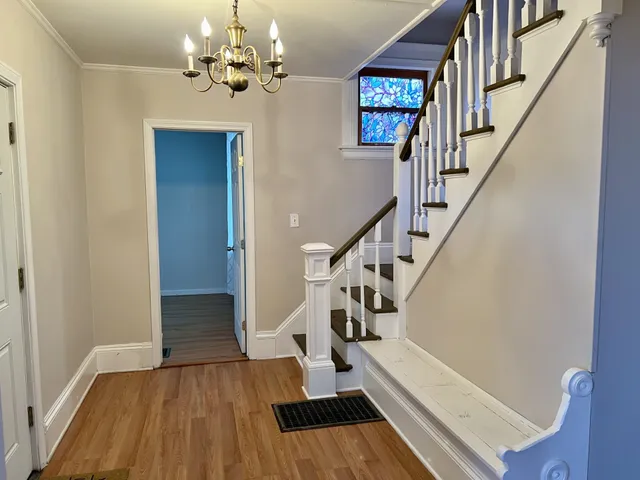 a view of entryway and hall with wooden floor