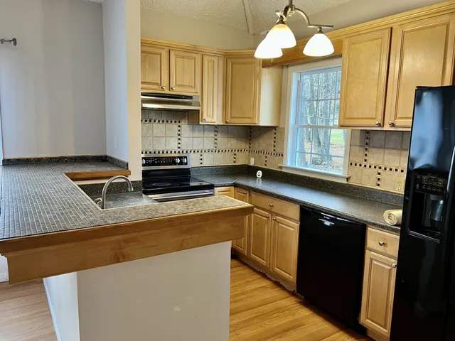 a kitchen with stainless steel appliances granite countertop a sink a stove and a refrigerator