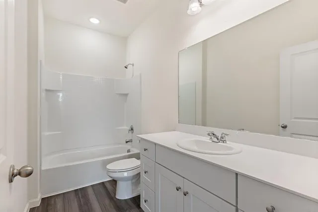 a bathroom with a granite countertop toilet a sink and a bathtub