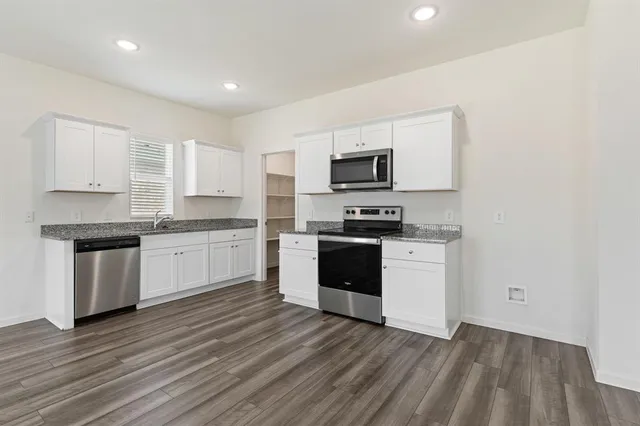 a kitchen with sink a microwave and cabinets