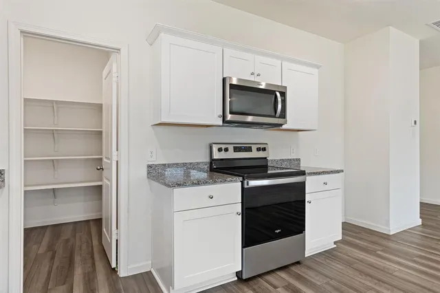 a kitchen with stainless steel appliances granite countertop a stove microwave and sink