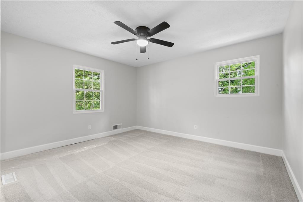 4510 Virginia Avenue Kennesaw, GA 30144 - Photo 31 of 54 an empty room with windows and ceiling fan