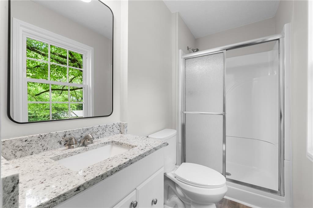 4510 Virginia Avenue Kennesaw, GA 30144 - Photo 39 of 54 a bathroom with a granite countertop sink toilet and shower
