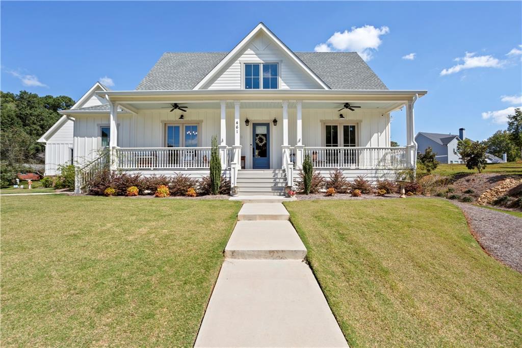 a front view of a house with a yard and potted plants